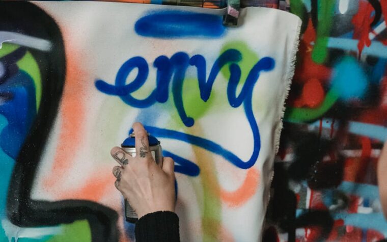 a person doing graffiti on a wall using a spray paint